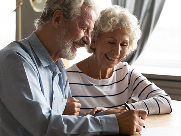 elderly couple signing papers<br />

